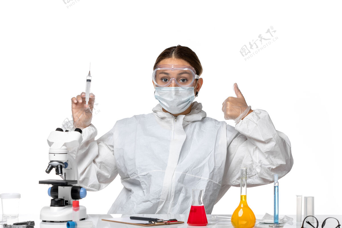 白人正面图：女医生穿着防护服 戴着口罩 拿着注射用的白色背景病毒药柯维德大流行外套人拿着