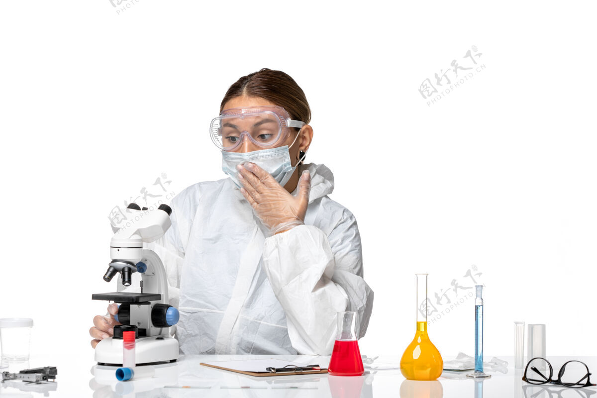 医生正面图女医生穿着防护服 戴着口罩用显微镜对着白色办公桌卫生大流行病毒冠状病毒人男人白色
