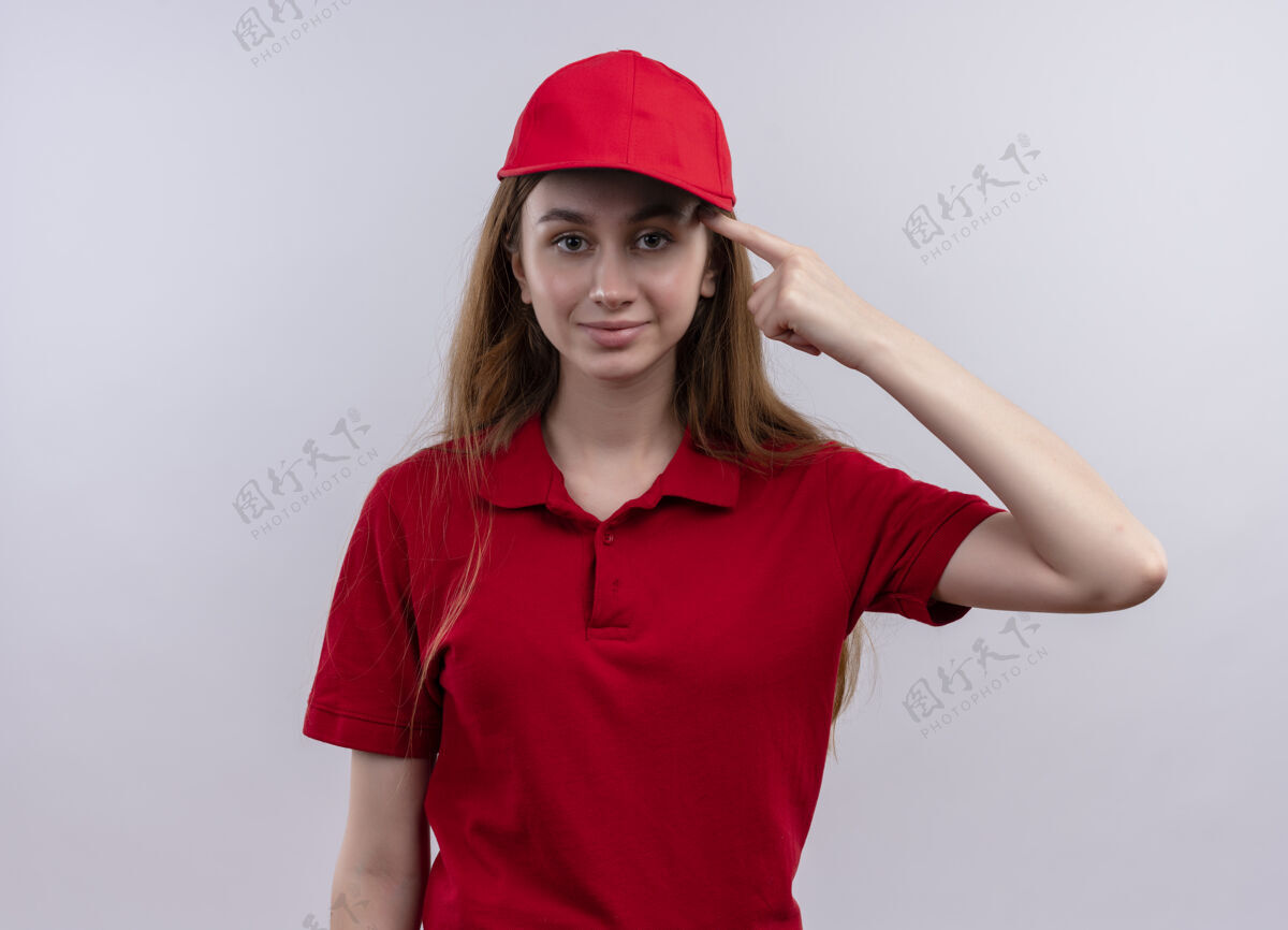 交货穿着红色制服的自信的年轻女送货员把手指放在隔离的白色空间的太阳穴上女孩手指信心