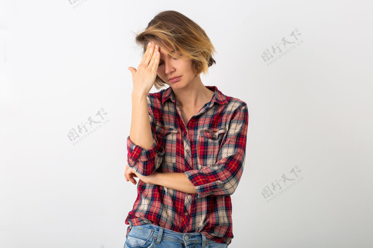表情穿着格子衬衫的年轻有趣的情绪化女人在白色的工作室墙上摆出孤立的姿势 表现出头痛的姿势手势休闲漂亮