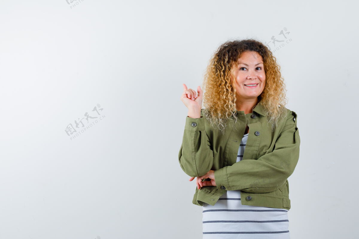 年轻一幅成熟女人的画像 她穿着绿色夹克 t恤 面带微笑 面带愉悦的前景色夹克休闲表情