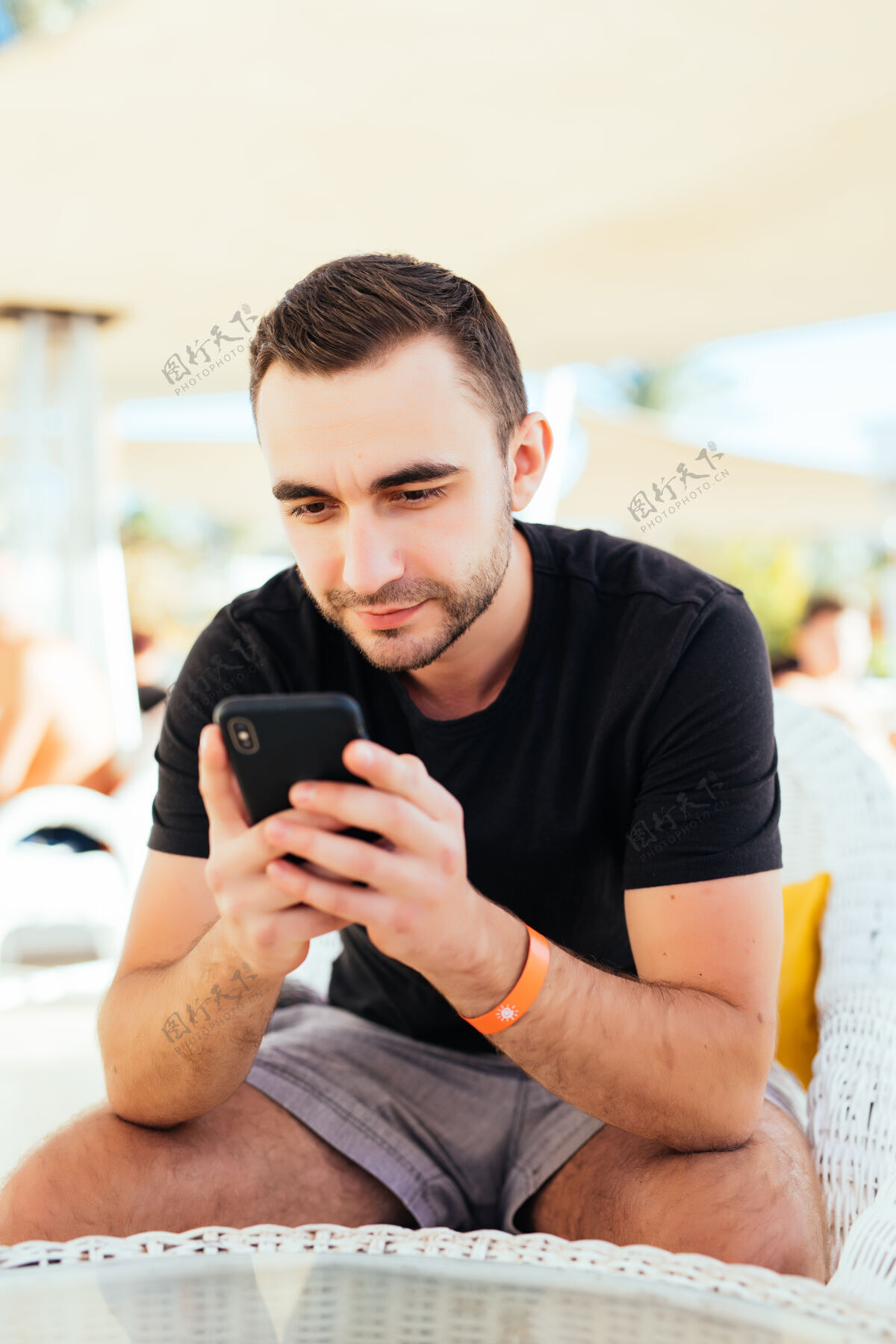手机在海滩避暑胜地的户外咖啡馆里 年轻人用手机打电话海滩人成人