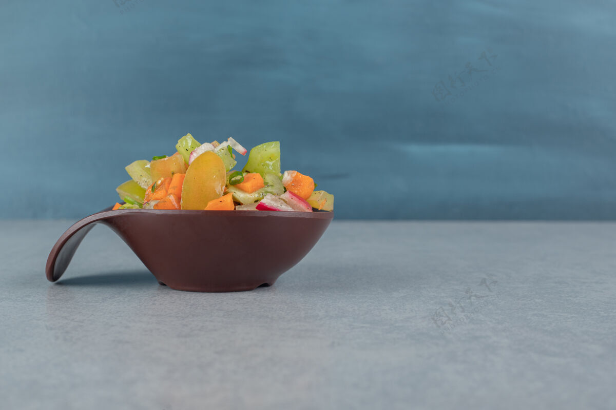 水果在水泥桌上的木制杯子里放着混合蔬菜沙拉午餐五颜六色早午餐