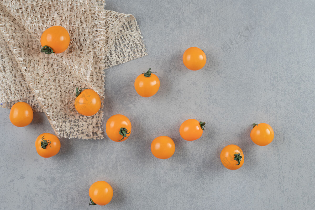 热带黄色的樱桃西红柿被隔离在水泥桌上灰色季节成分
