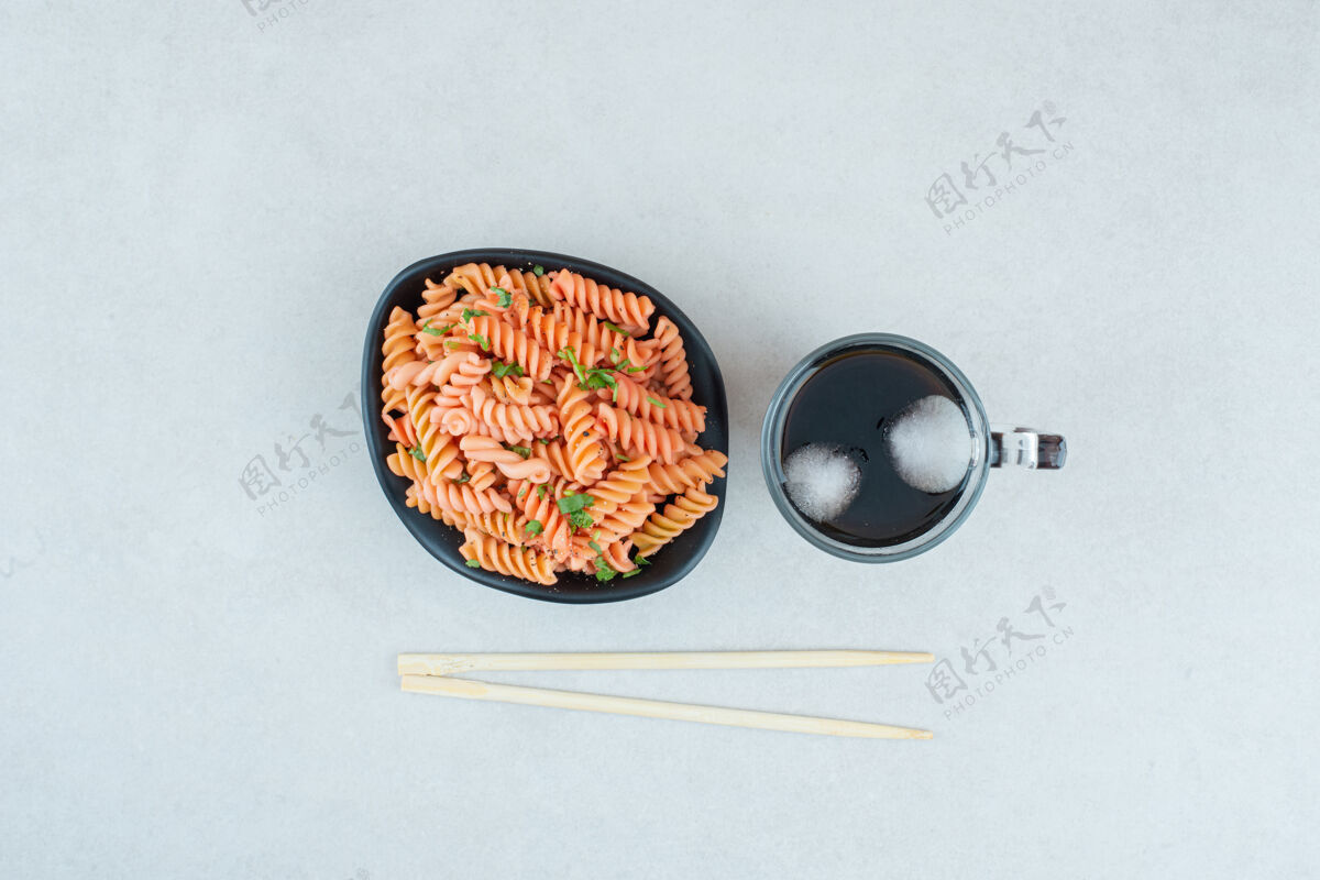 盘子美味的螺旋通心粉配冰茶和筷子好吃凉日式