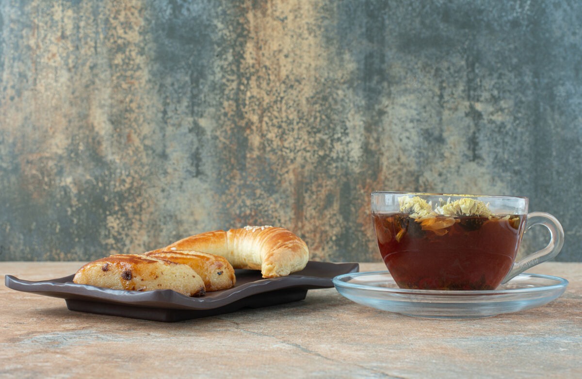糕点美味的甘菊茶和饼干放在大理石桌上热的甘菊草药