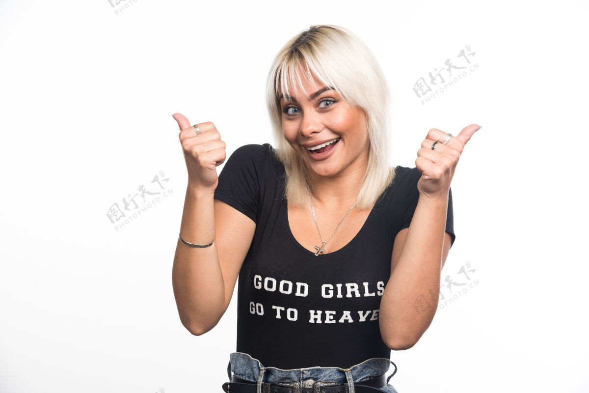 肖像快乐的女人在白墙上竖起大拇指请竖起大拇指成人