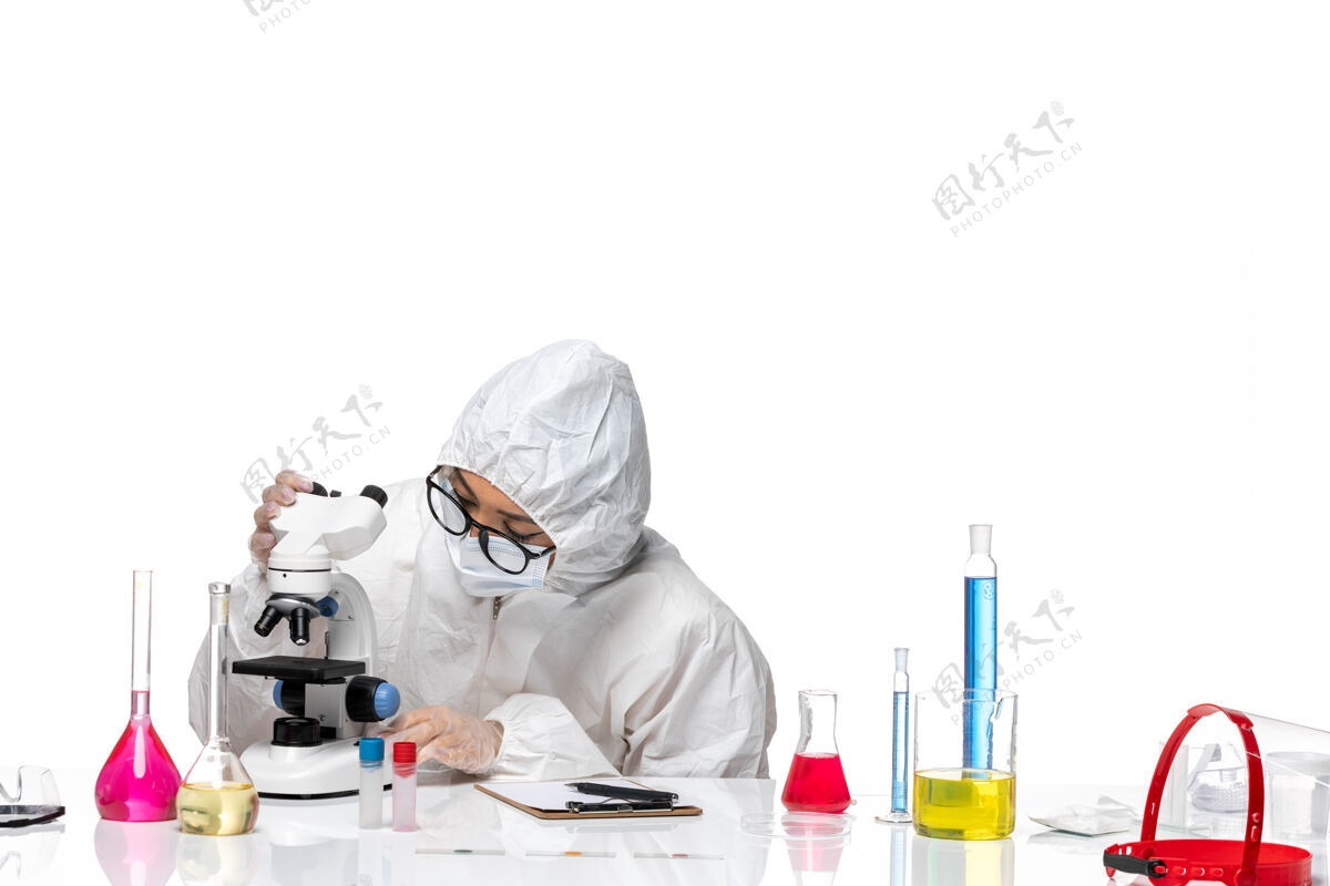 女化学家前视图穿着特殊防护服的女化学家在白色背景的化学病毒实验室里用不同的溶液工作套装医学观点