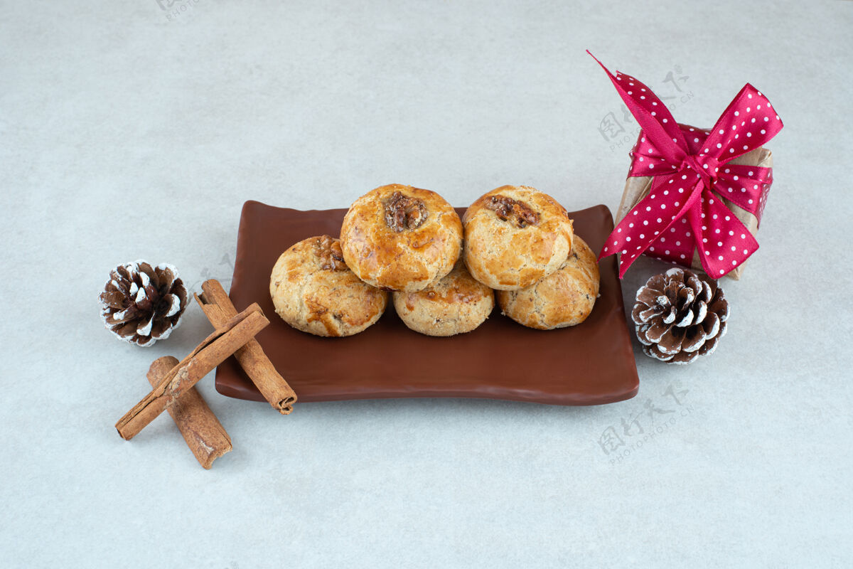 肉桂一盘黑色的饼干 里面有圣诞小礼物和松果蝴蝶结食品盒子