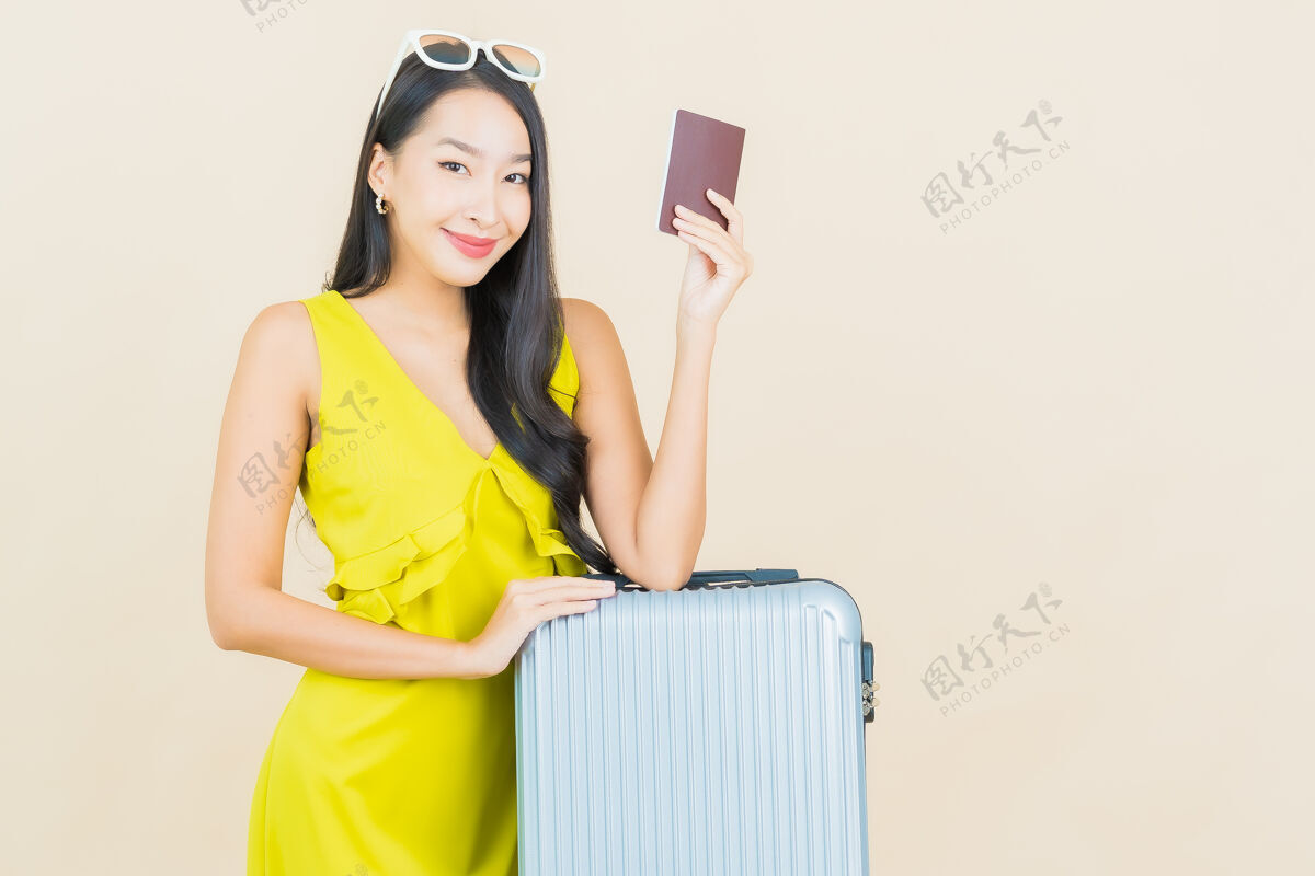 年轻肖像美丽的亚洲年轻女子带着行李护照准备在彩色墙上旅行人独唱女性
