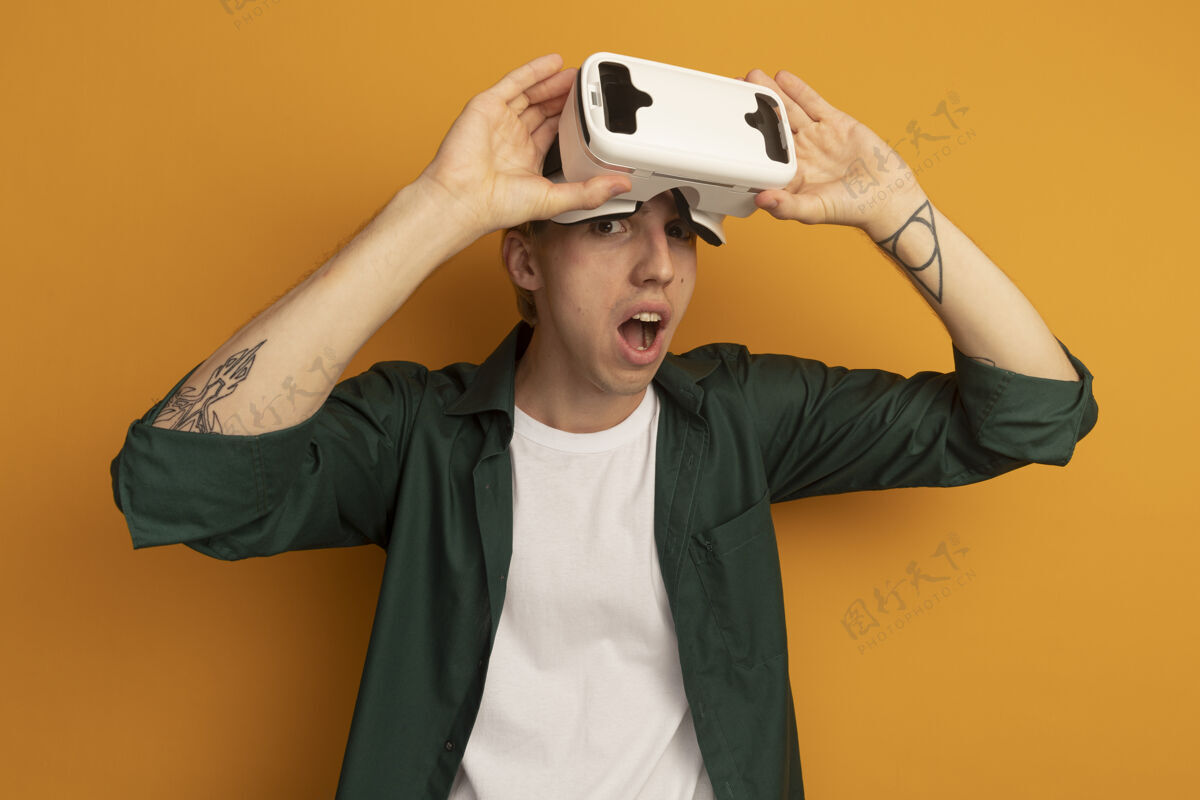 戴一个穿着绿色t恤和vr耳机的年轻金发男人玩家科技虚拟现实