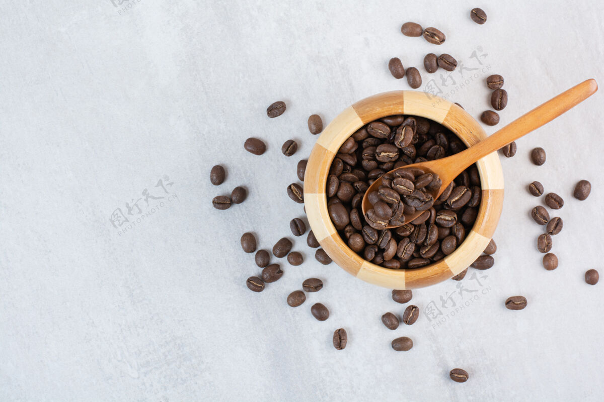 粉用勺子把咖啡豆放在木碗里咖啡豆香味