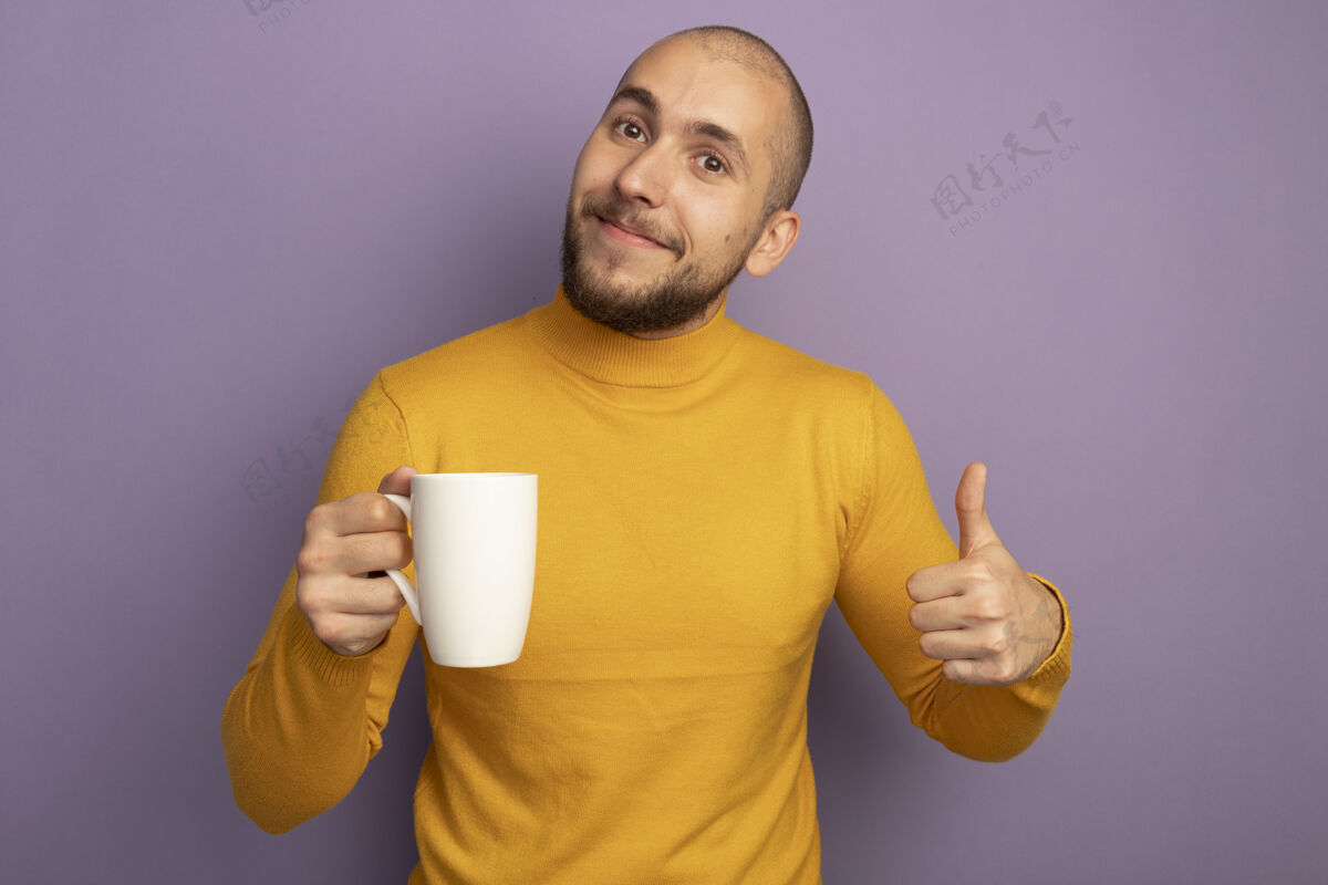 小伙子高兴地直视前方 年轻帅哥端着一杯茶 在紫色地上竖起大拇指年轻帅哥杯子