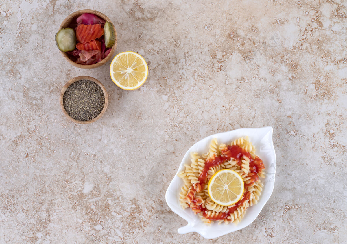 各式意大利面拼盘 柠檬片 什锦泡菜和一碗黑胡椒放在大理石表面餐风味碗
