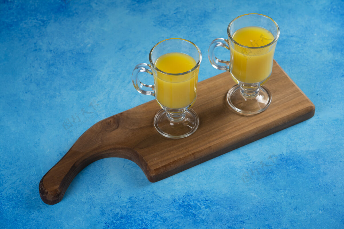 柑橘在木板上放两杯橙汁马克杯冰沙营养