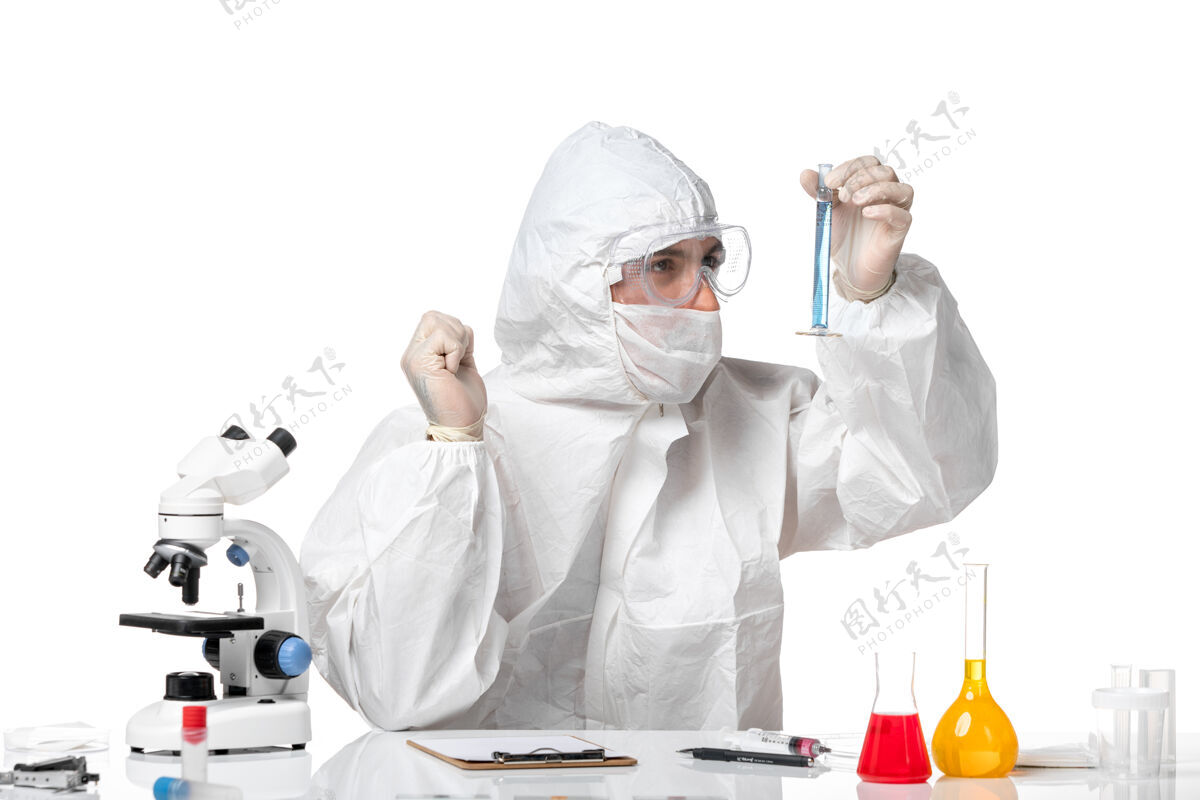 防护正面图：男医生穿着防护服 戴着面罩 因为在空白处有蓝色溶液的瓶子套装病毒医疗