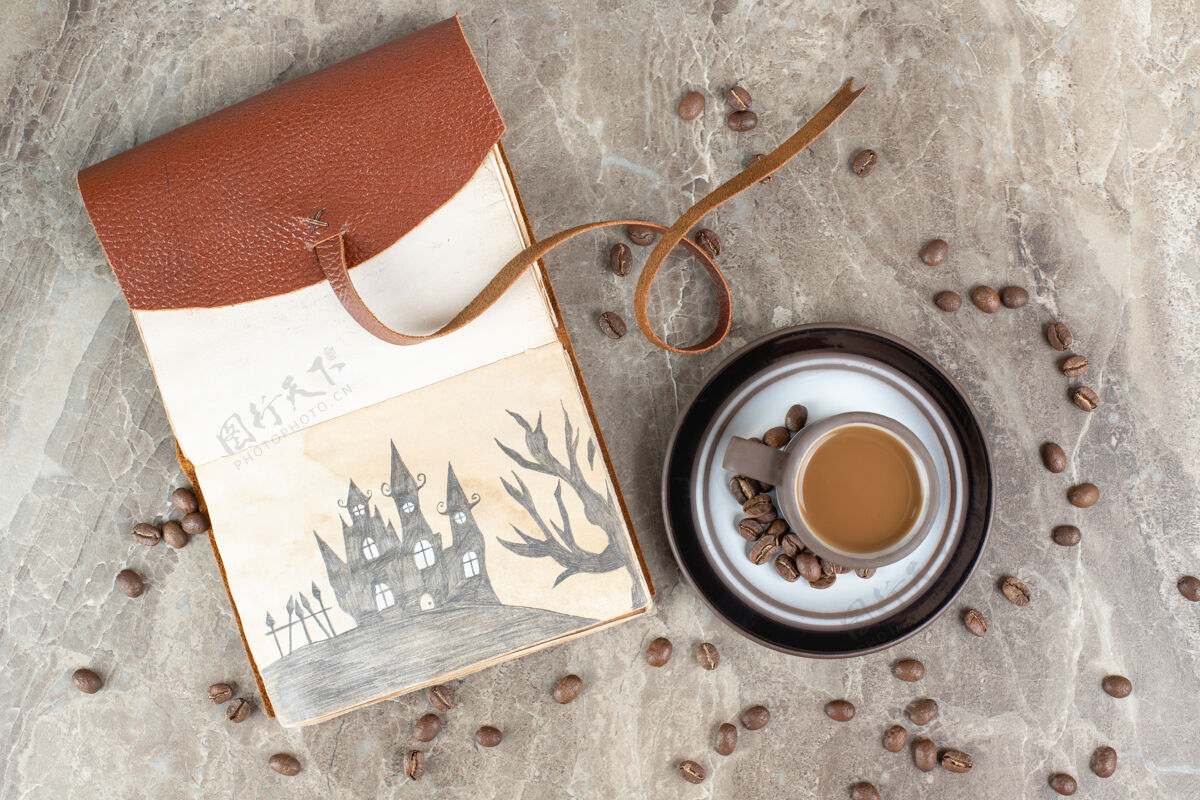 香味咖啡杯 咖啡豆和笔记本放在大理石表面咖啡因杯子热的