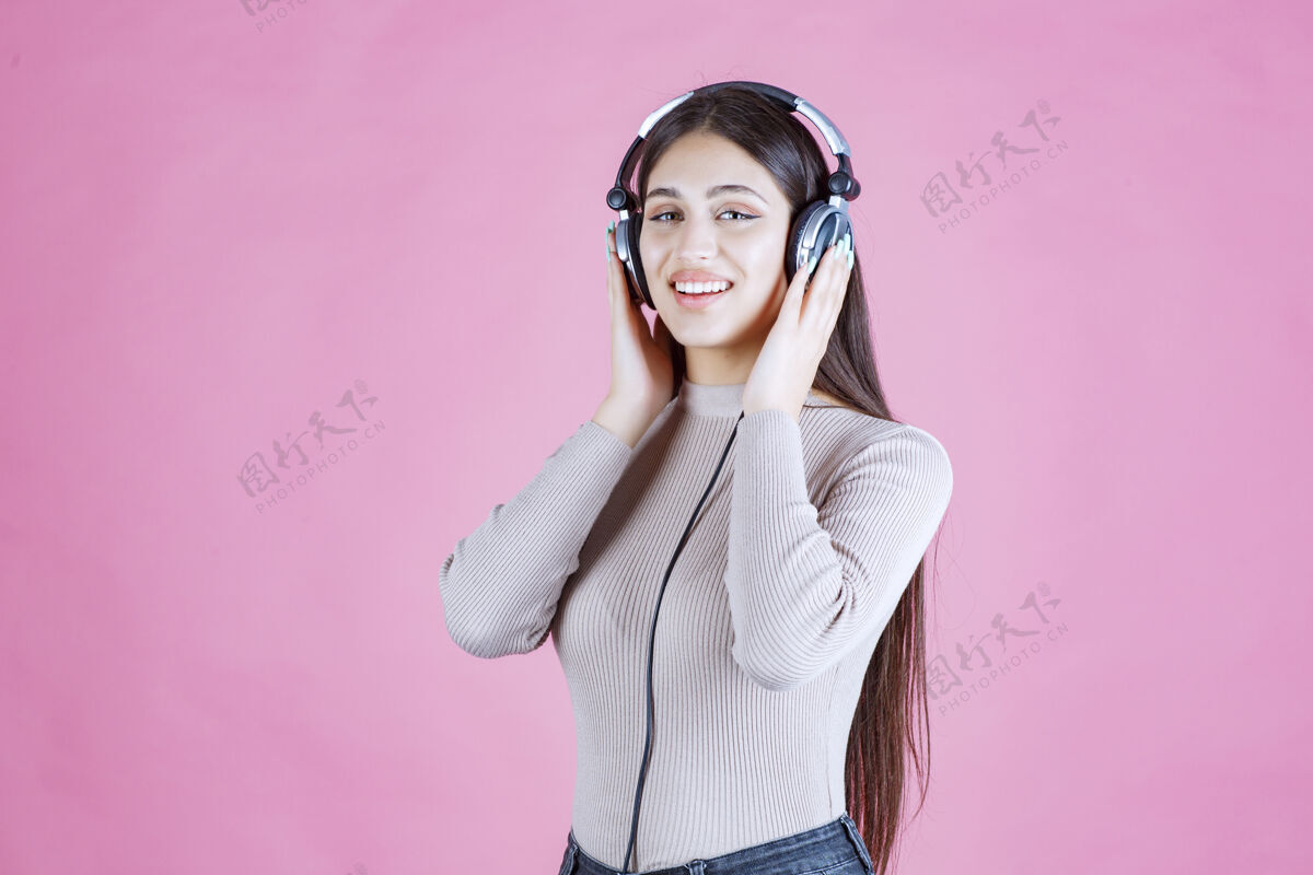 休闲戴着耳机的女孩听着音乐 感觉很开心姿势轨道舞蹈