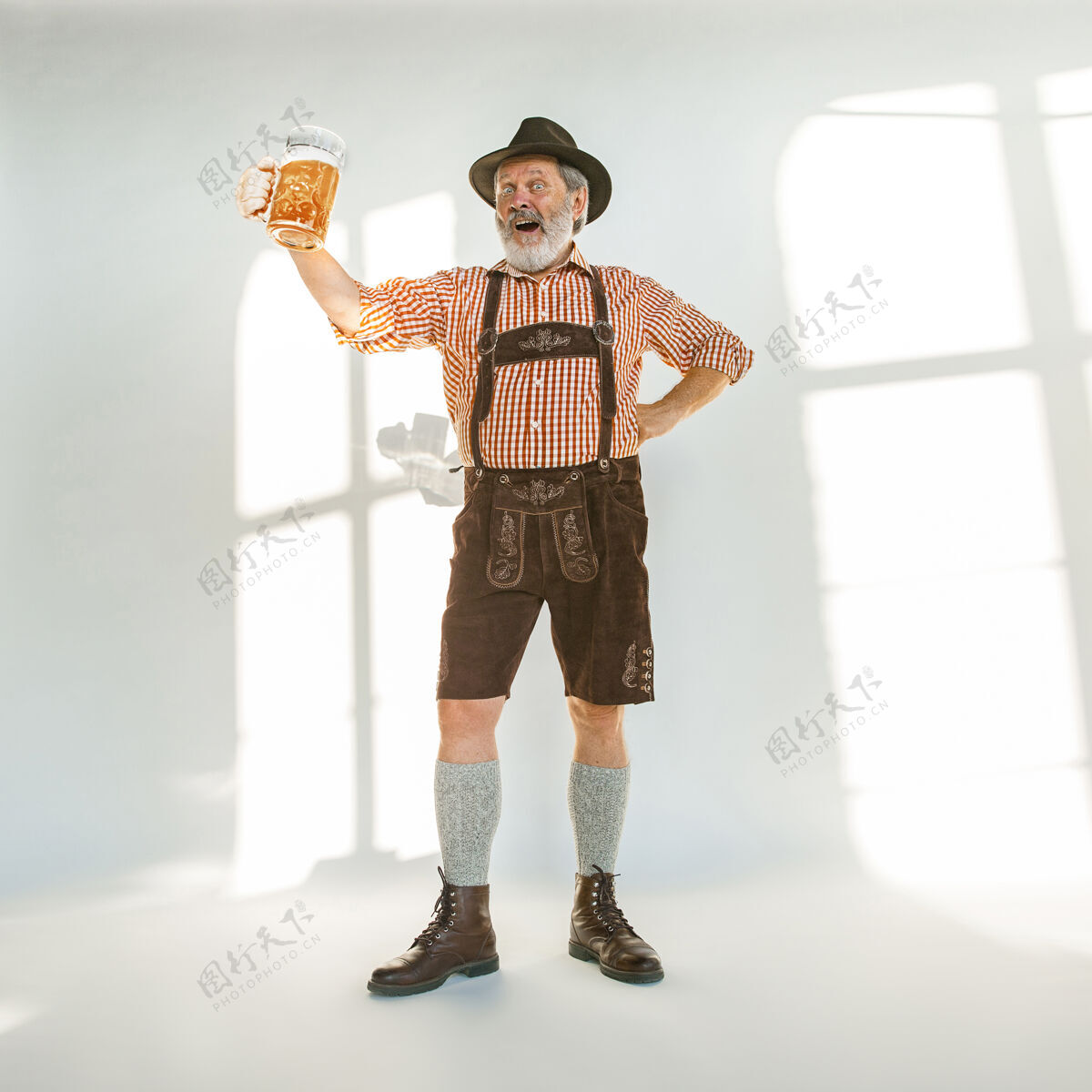 文化啤酒节高级男士的肖像 戴着帽子 穿着传统的巴伐利亚服装在白色背景的摄影棚拍摄的男性全长庆祝 节日 节日的概念喝啤酒表达德语啤酒