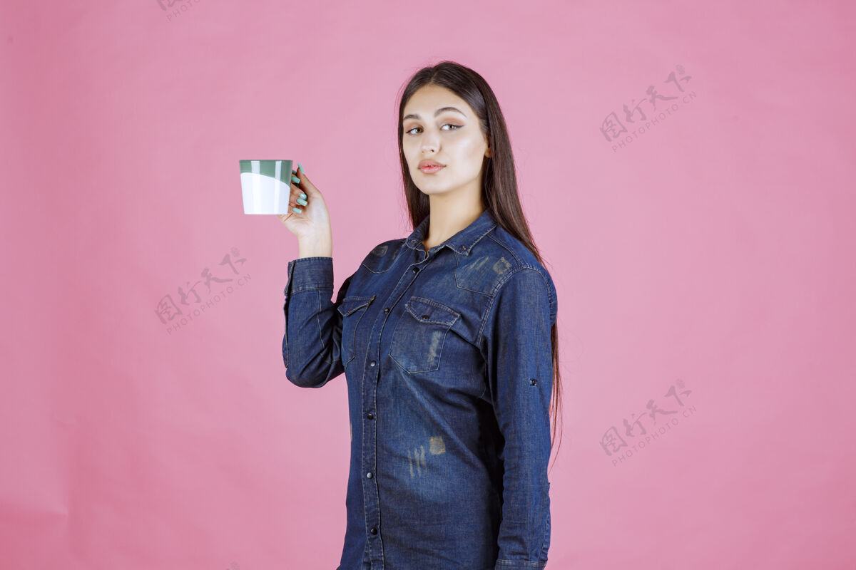 女人女孩拿着一个白绿色的咖啡杯 闻着商业冬天人类