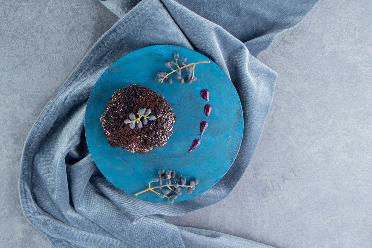 片蓝色盘子上的巧克力蛋糕糖自制招待