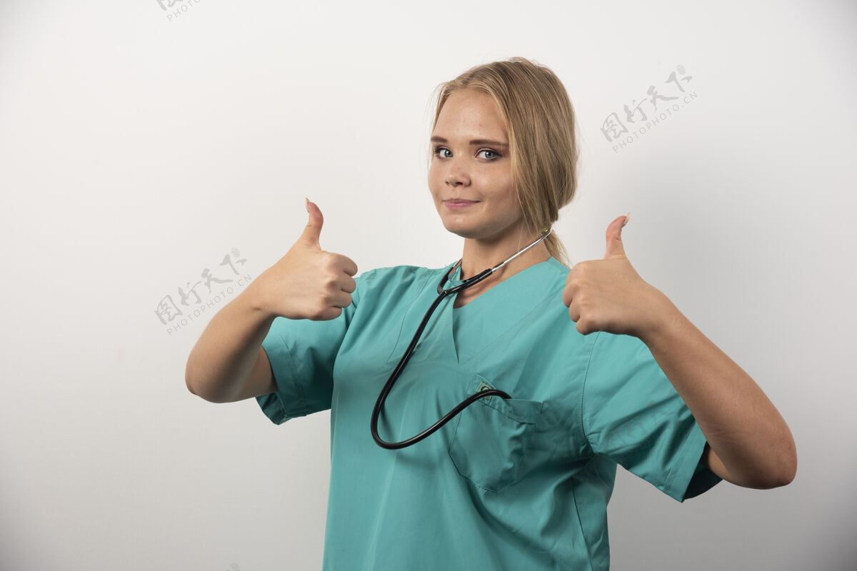 女孩正面女医生在白色背景上竖起大拇指高质量照片女听诊器专业