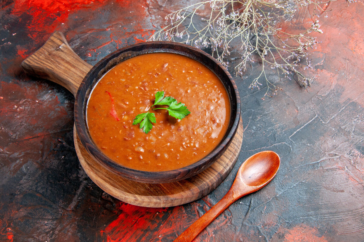 汤棕色砧板上的西红柿汤和五颜六色桌子上的勺子勺子混合物蔬菜