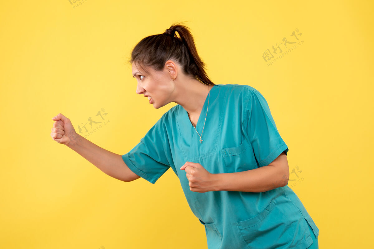 人正面图黄色背景上穿着医用衬衫的女医生威胁运动装医疗