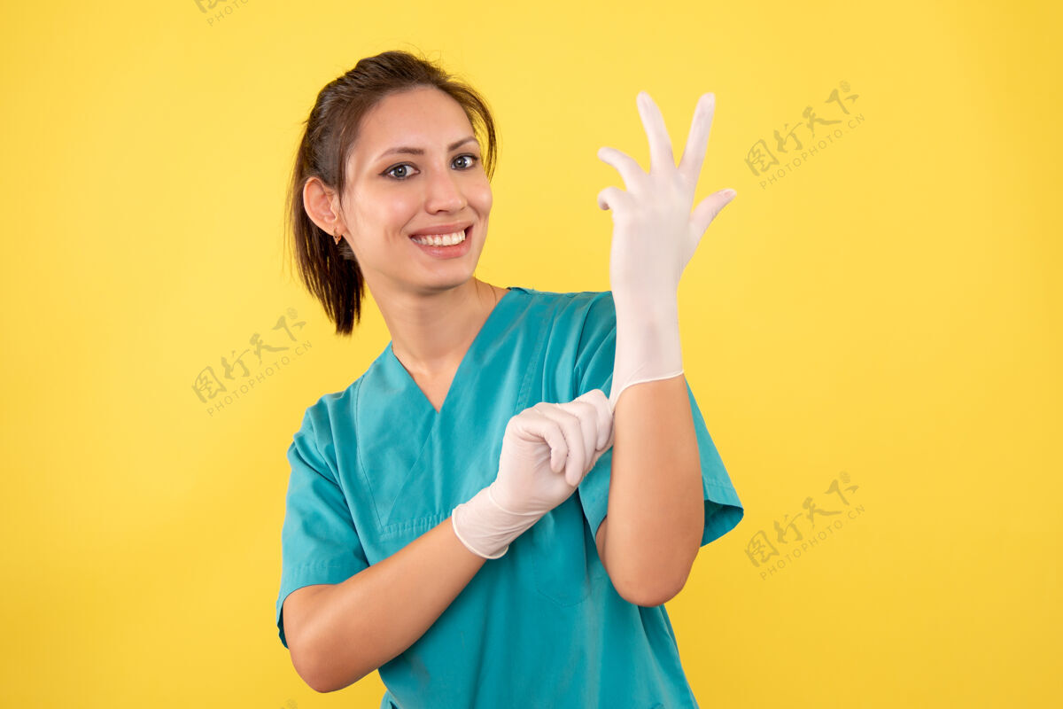肖像正面图黄色背景戴手套的女医生黄色佩戴健康