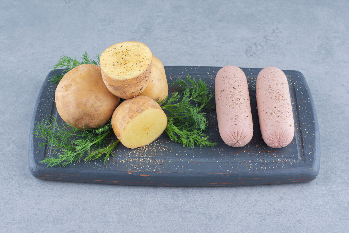 肉木板上有美味的香肠 土豆和蔬菜酱汁烹饪食物