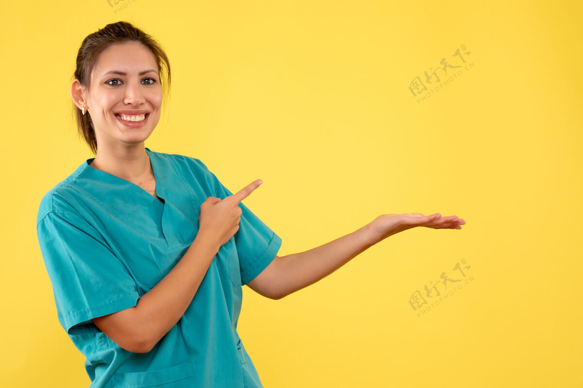 成人前视图黄色背景上穿着医用衬衫的女医生一视图正面