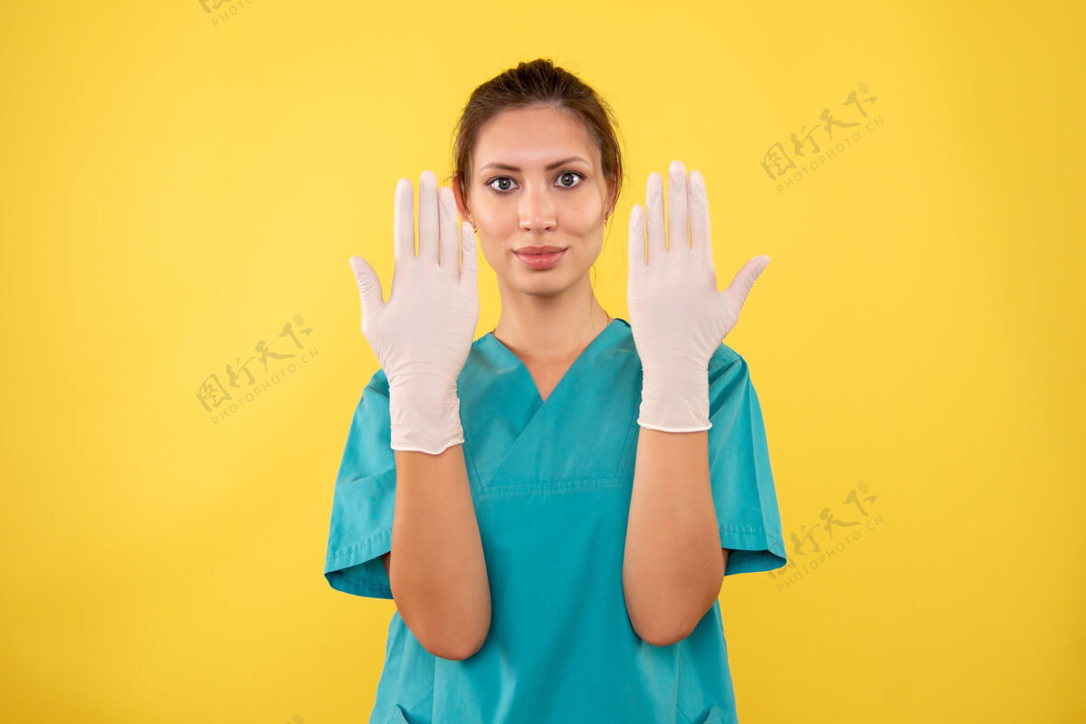 医疗前视图黄色背景上戴手套的女医生微笑健康成人