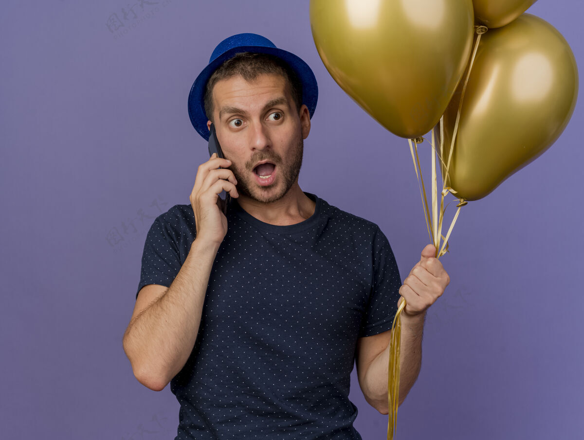 电话一个戴着蓝色帽子的白人帅哥拿着氦气球在电话里讲话 紫色的背景上留着空白男人气球紫色