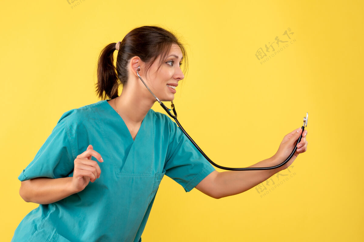 专业正面图黄色背景 穿着医用衬衫 带听诊器的女医生女医生黄色衬衫