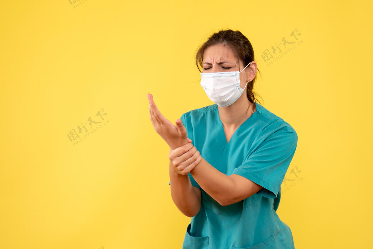 流行病前视图穿着医用衬衫和面罩的女医生在黄色背景上伤了手面具伤害肖像