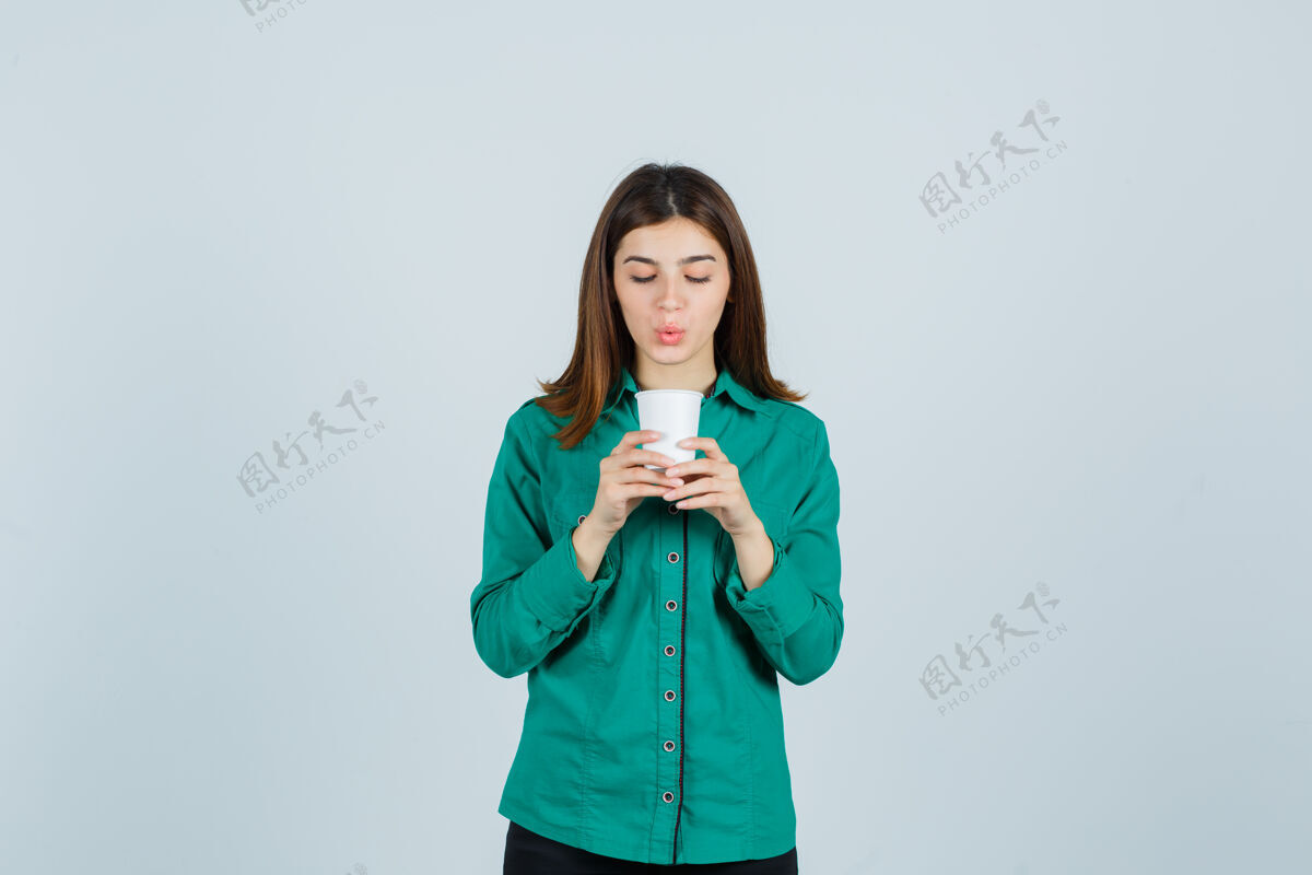 女孩年轻的女士拿着一杯塑料咖啡 穿着衬衫 看起来很专注 正对着前方咖啡头发年轻