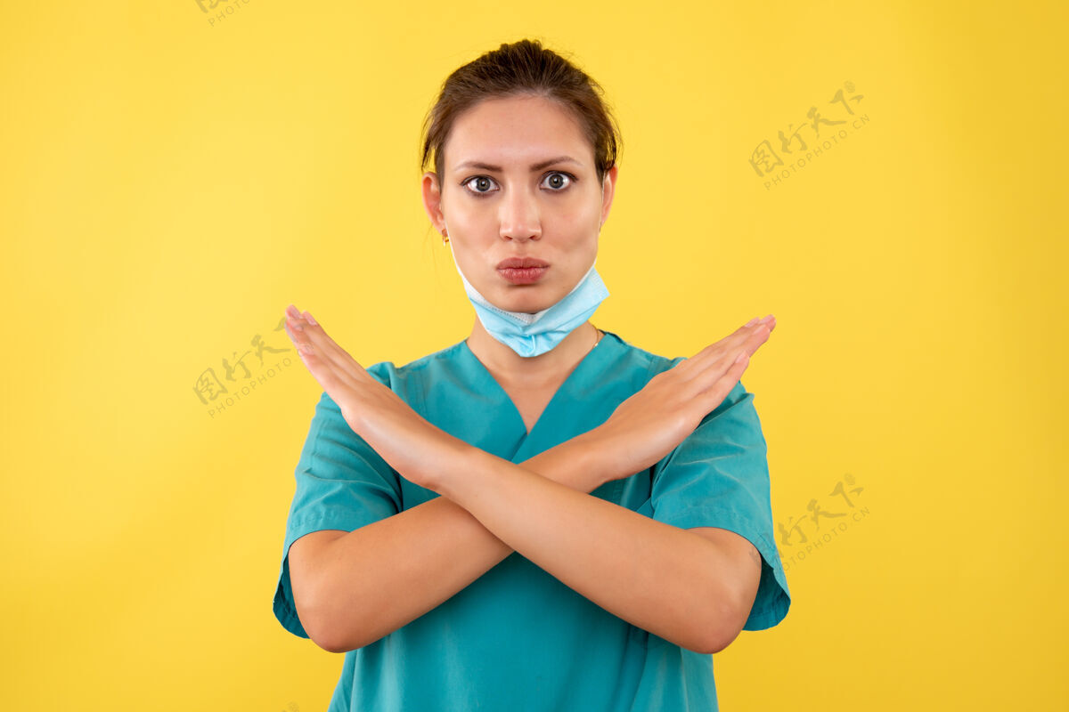 护士黄色背景上戴着无菌口罩的女医生的前视图情绪人病毒