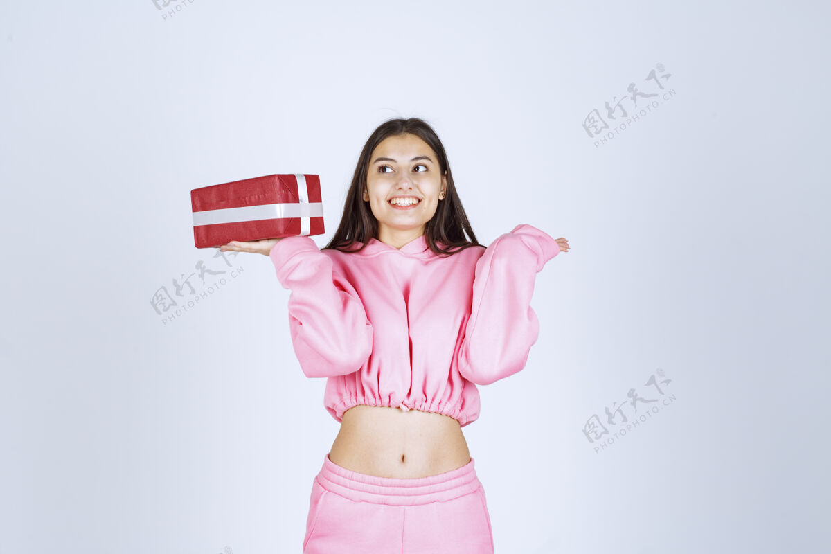 服装穿着粉色睡衣的女孩手里拿着一个红色长方形礼盒 看上去很满意女性人类人类