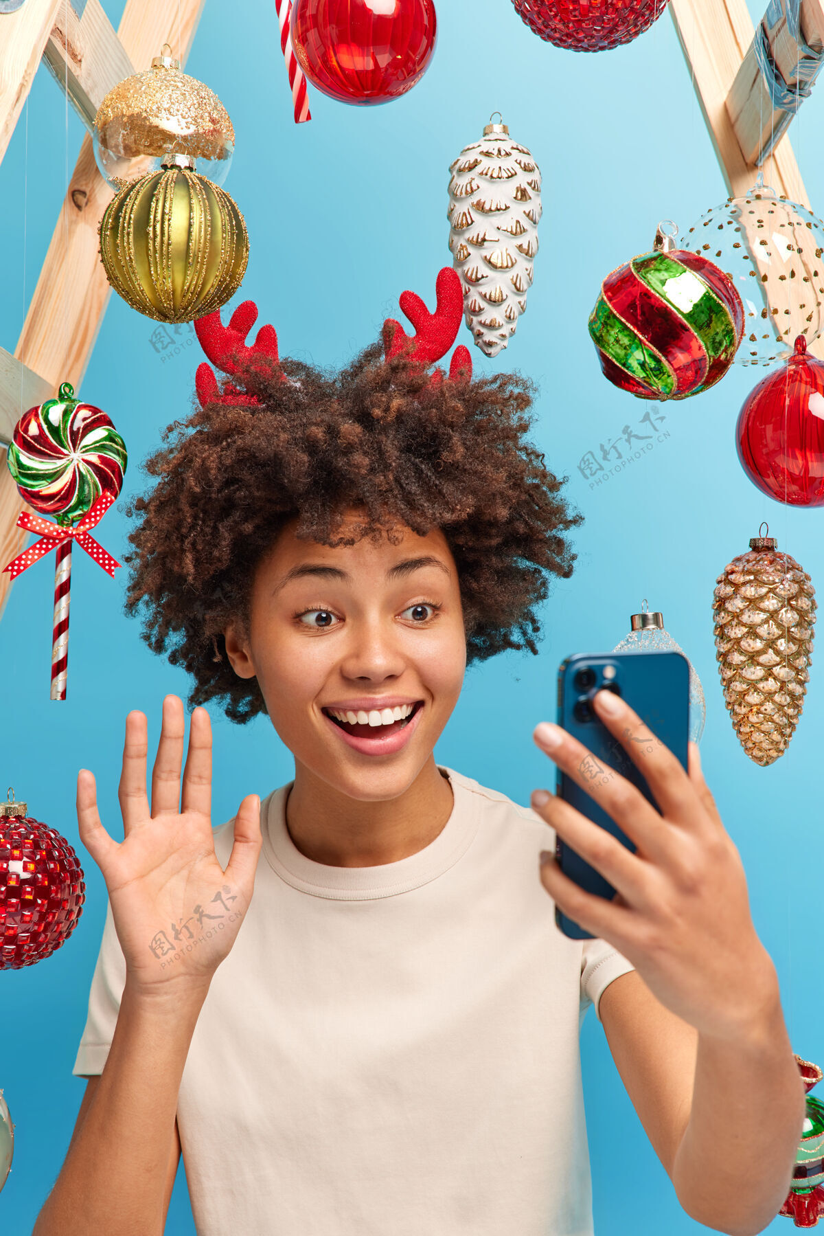 传统快乐快乐的非洲裔美国妇女在智能手机屏幕前挥手打电话亲戚们在圣诞节期间呆在家里享受舒适的气氛在寒假前装饰房间喜庆的心情拍摄圣诞节高兴