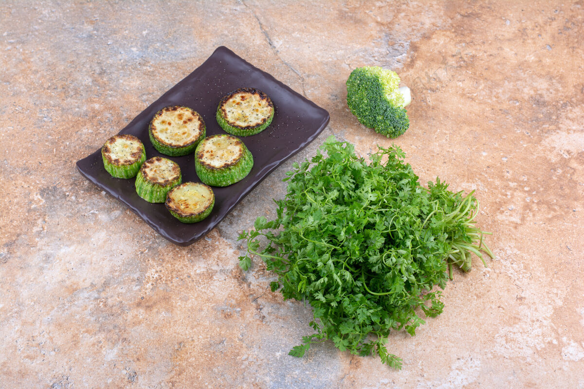 切片一捆香菜 一片西兰花和一盘炸西葫芦放在大理石表面香菜营养健康