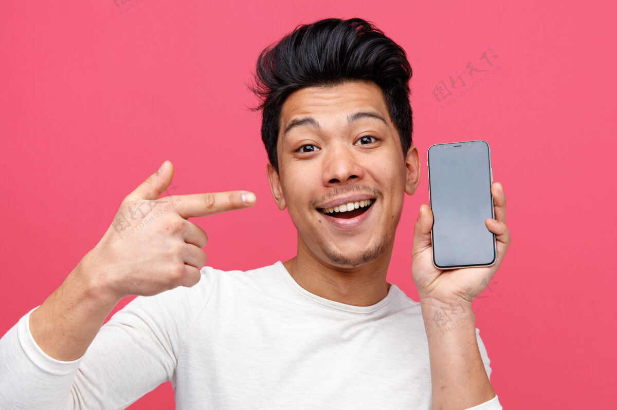 手机激动的年轻人手持并指着手机的特写镜头粉色男人年轻