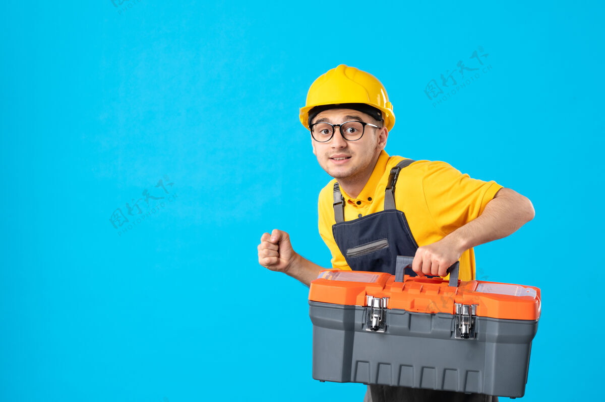 建筑工人穿着黄色制服的男工人的正面图 蓝色的工具箱承包商服务工具