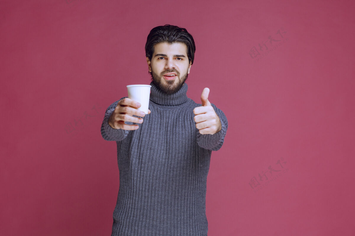 喜欢男人拿着一个一次性咖啡杯 做着享受的手势年轻人姿势人类