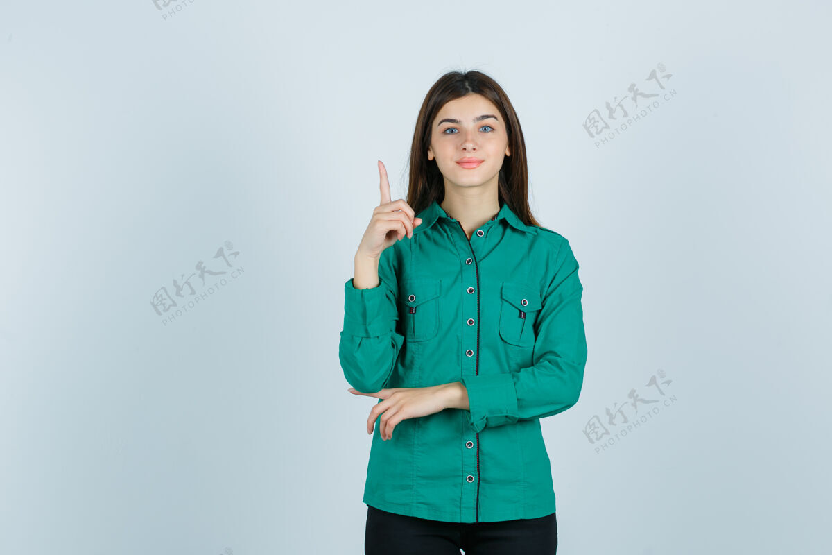 年轻一幅年轻女性的画像 她穿着绿色衬衫朝上 看上去很快乐无忧无虑节日指向