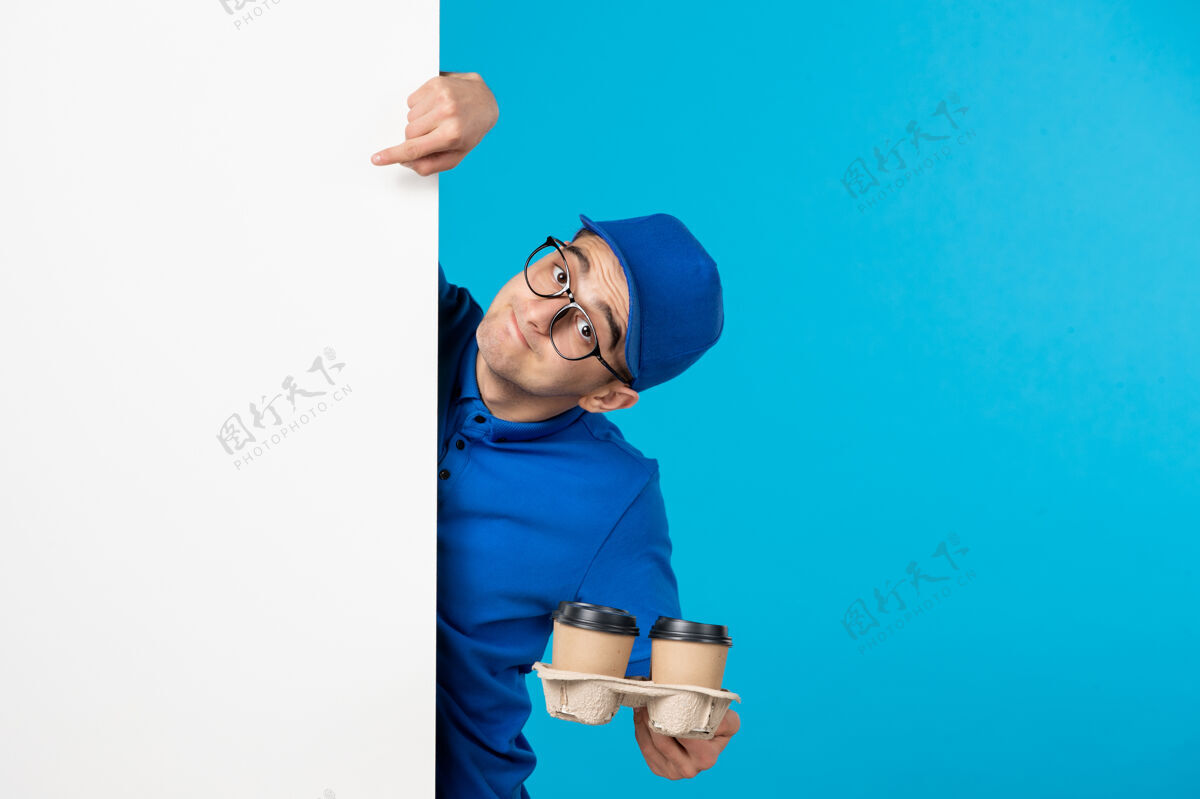 送货身穿蓝色制服的男信使的正面图 蓝色上有咖啡服务咖啡漂亮