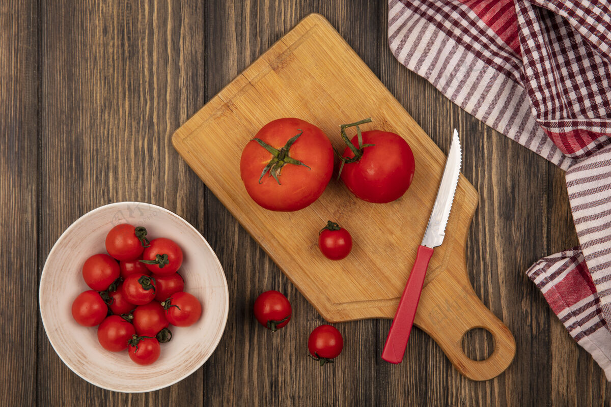 刀顶视图新鲜的红色西红柿在一个碗上 西红柿在一个木制的菜板上 刀在木制的表面饮食营养板