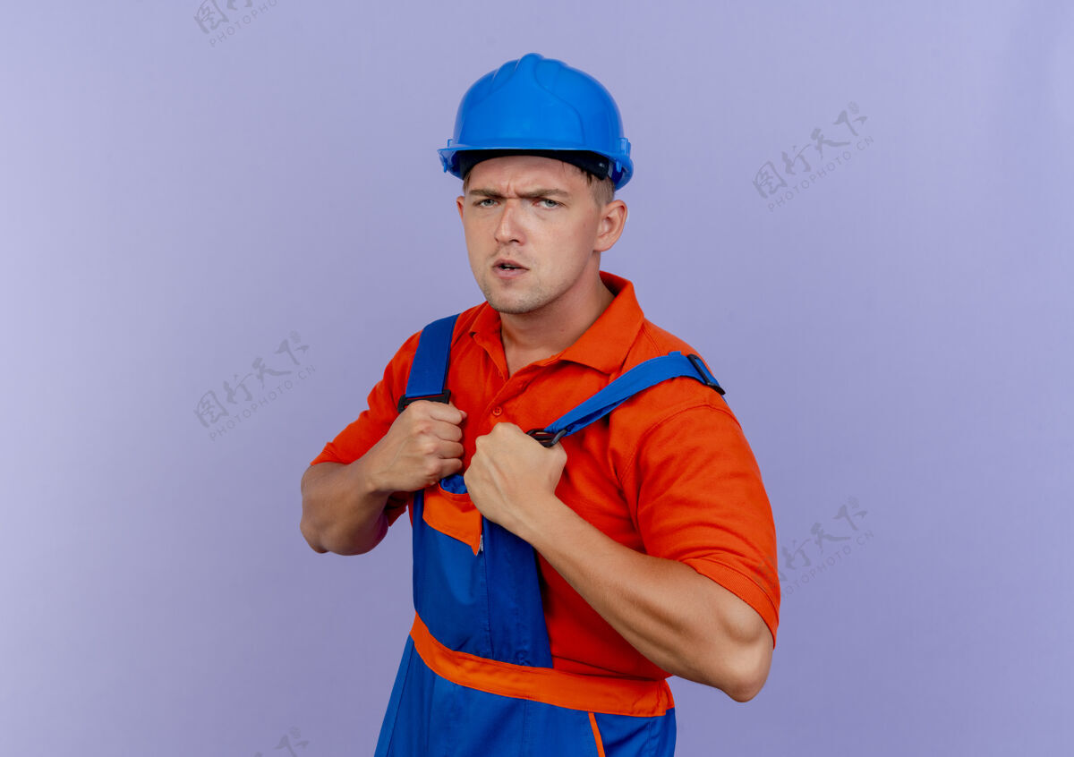 自信自信的年轻男性建筑工人穿着制服和安全帽抢制服抢安全头盔