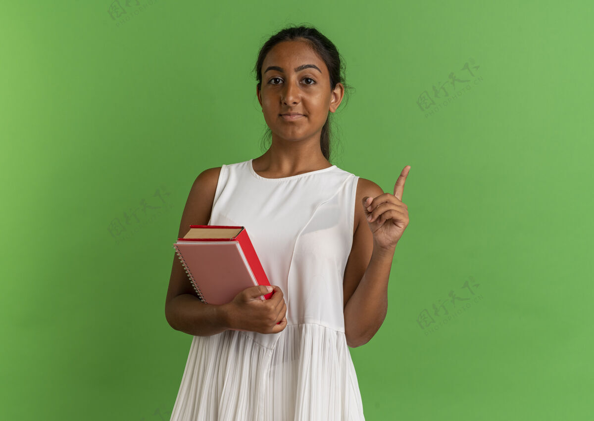 拿着年轻的女学生拿着笔记本 指着上面的书女孩笔记本女学生