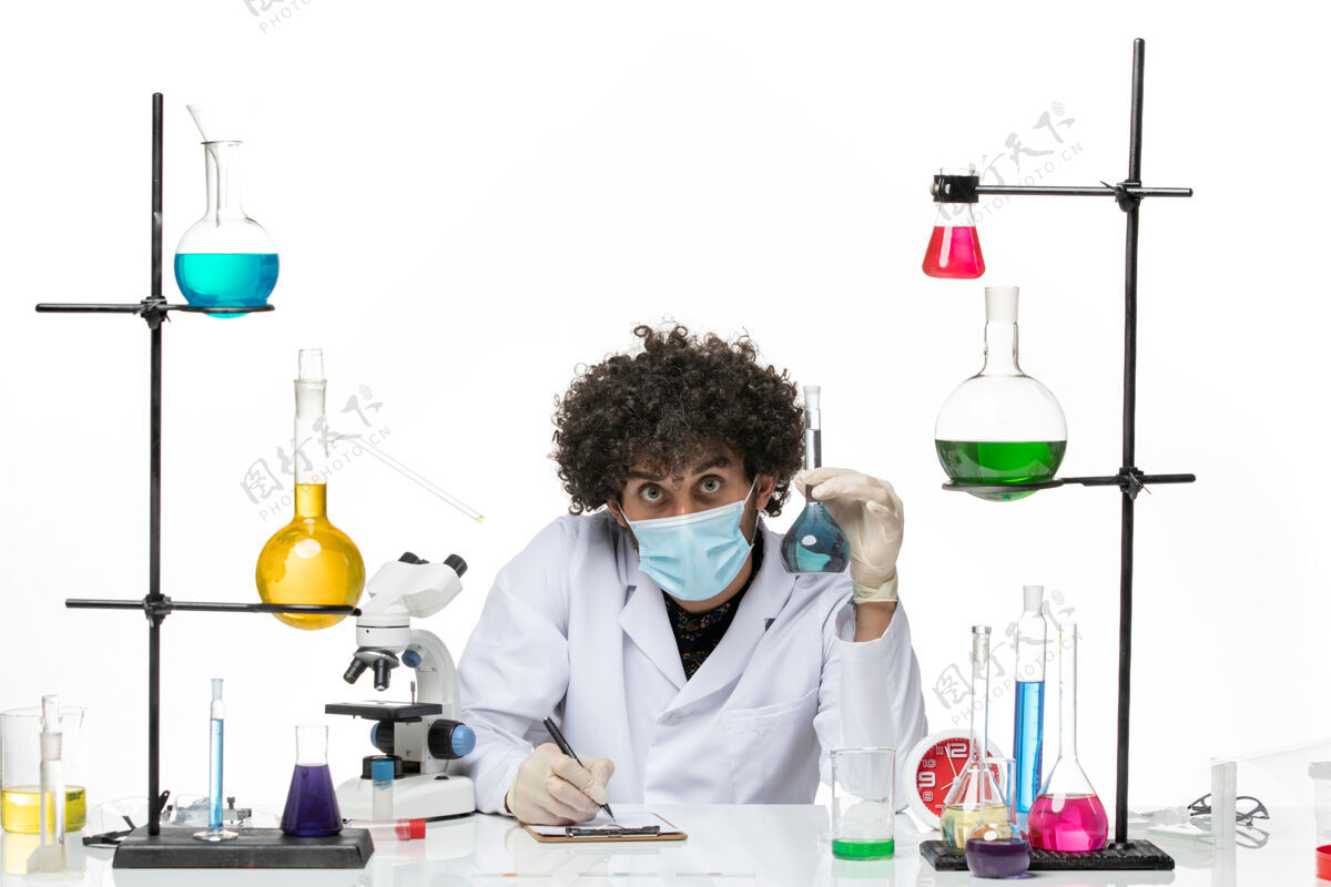 正面正面图：男化学家 穿着白色医疗服 戴着口罩 拿着溶液 在空白处写字溶液男性专业