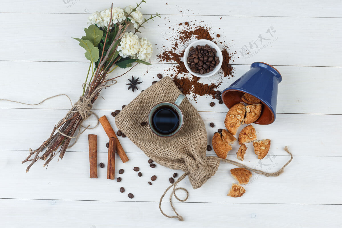 种子一套咖啡豆 饼干 鲜花 肉桂棒和咖啡在一个木杯和袋子背景顶视图套装艺术咖啡馆